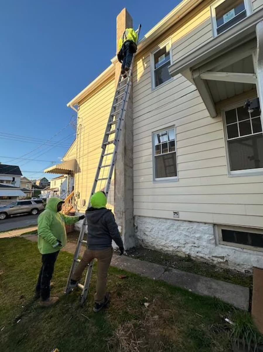 House Buying Solutions construction crew working on a roof replacement at a NEPA property